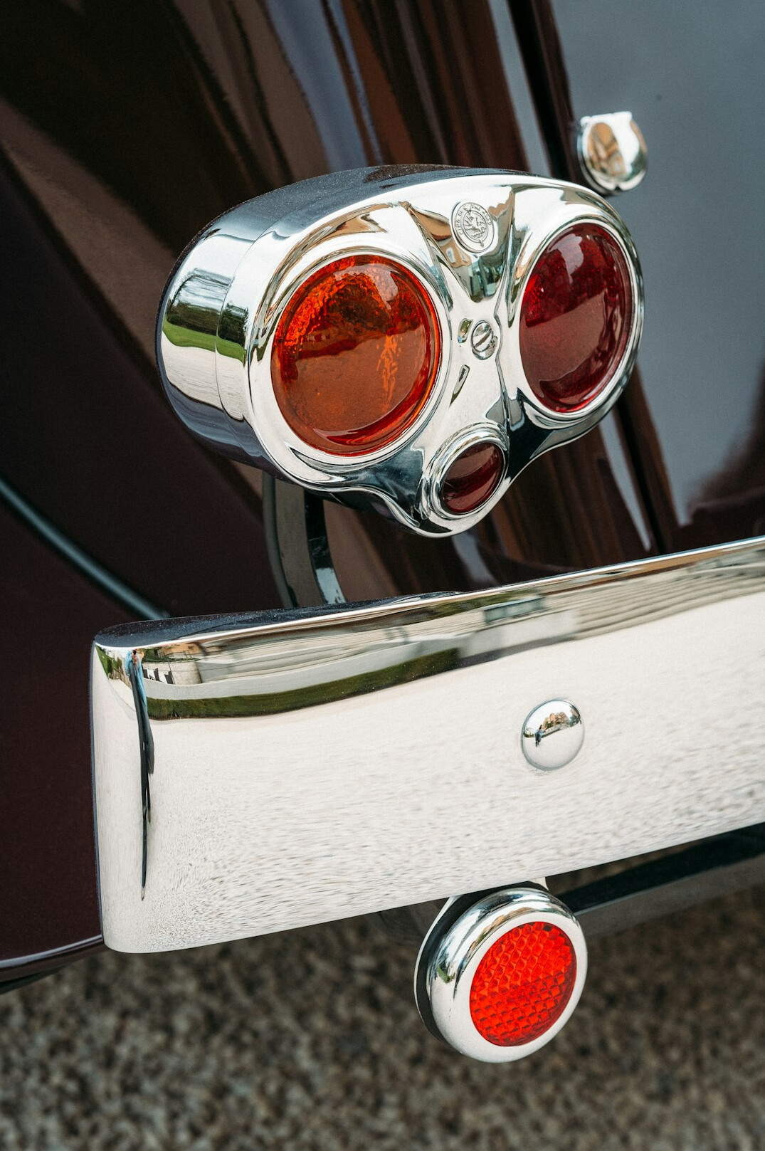 Close-up of a vintage chrome car hood ornament and headlight
