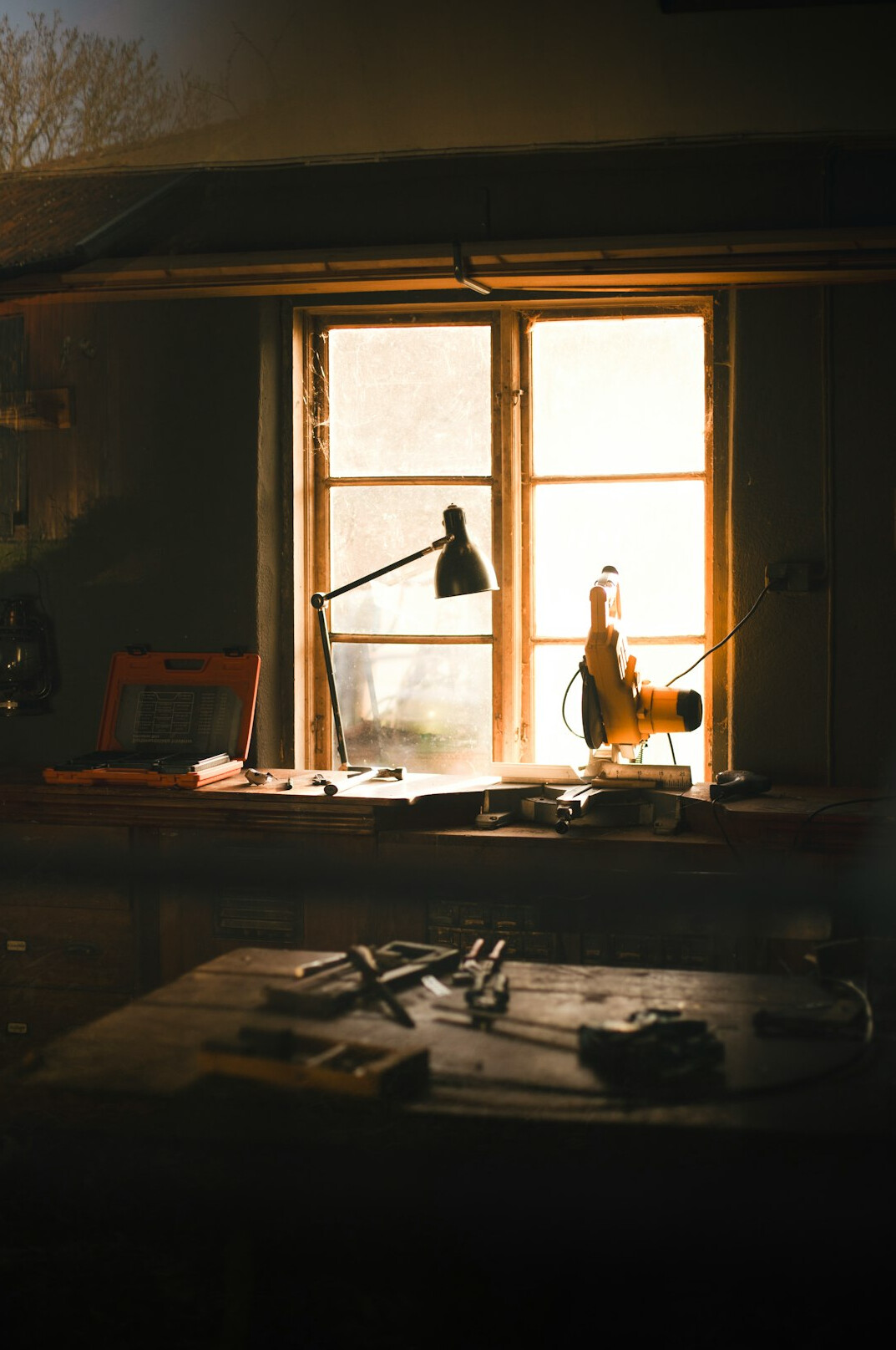 Watchmaker bench with vintage watch movements and tools in warm light